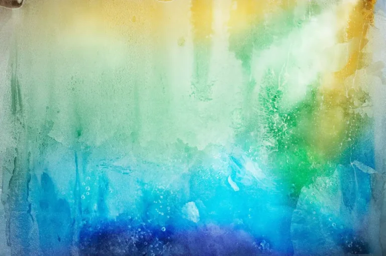 Abstract gradient of yellow, green, and blue light refracting through ice